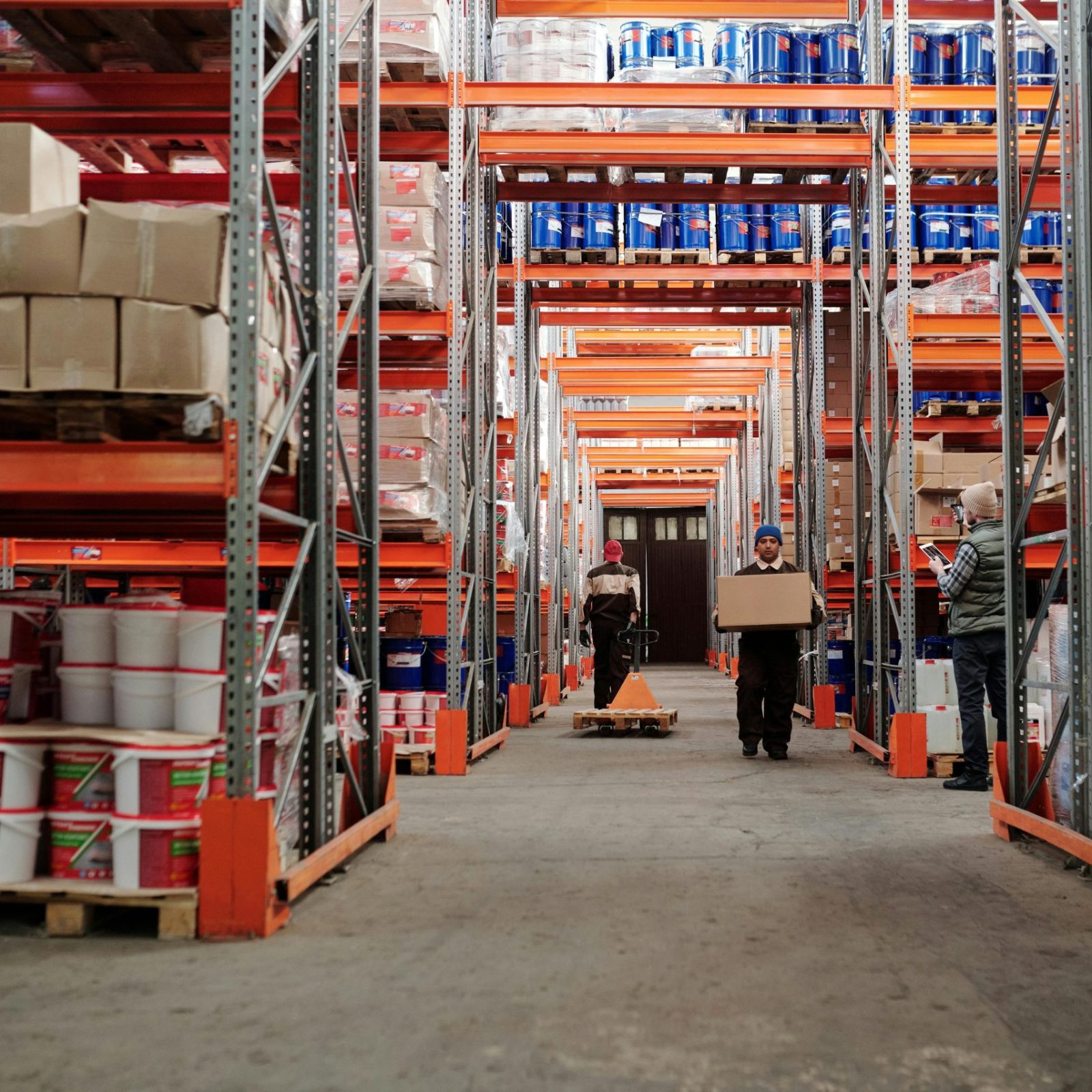 pexels-photo-4483862-4483862 Warehouse interior showing workers handling boxes and organized shelves filled with products.